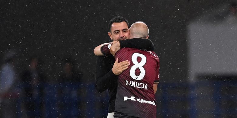 Andres Iniesta dan Xavi Hernandez berpelukan dalam laga uji coba antara Vissel Kobe vs Barcelona di Japan National Stadium, Tokyo, 6 Juni 2023. (Photo by Yuichi YAMAZAKI / AFP)