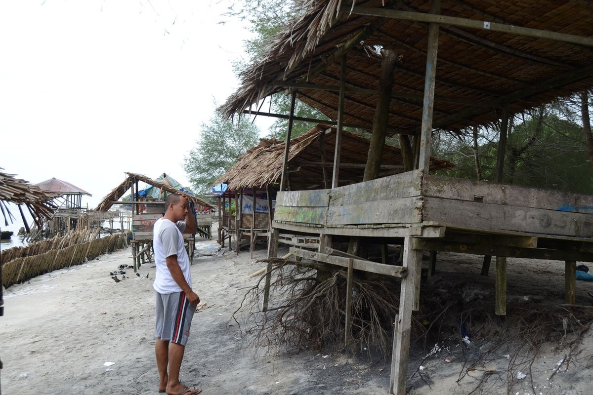 Dua orang warga menunjuk gubuk yang terdampak abrasi hebat di kawasan wisata di Pantai Labu, Deli Serdang, beberapa waktu lalu. Abrasi ini diakibatkan semakin rusaknya hutan mangrove dan pengambilan pasir laut di sekitar kawasan tersebut. Pemerintah kembali mengizinkan ekspor pasir laut setelah dihentikan sejak tahun 2003 silam.