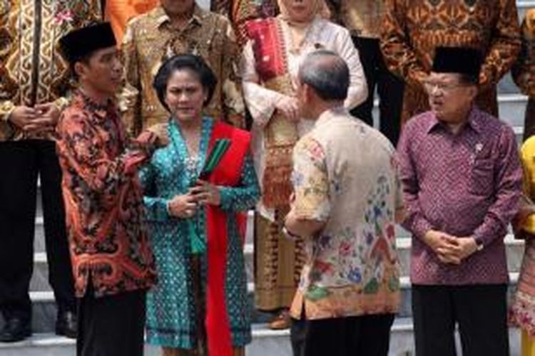 Presiden Joko Widodo didampingi Ibu Negara Iriani Widodo berbincang dengan protokoler bersama Wakil Presiden Jusuf Kalla di sela acara foto bersama anggota Kabinet Kerja di Istana Merdeka, Jakarta, Senin (27/10/2014).