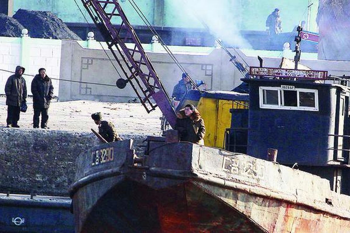 Sejumlah pria  berdiri di tepi sungai di kota Sinuiju, Korea Utara, yang membatasi negeri itu dengan kota Dandong, China, Jumat (30/12). Pemerintah Korut hari itu memperingatkan Korea Selatan dan negara lain agar tak mengharapkan perubahan setelah kematian pemimpin Korut Kim Jong Il, dan menegaskan putra Kim Jong Il, Kim Jong Un, sebagai pemimpin baru mereka.