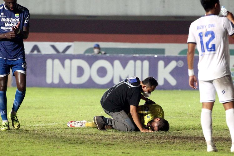 Dokter Arema FC dr. Nanang Tri Wahyudi SpKO berkomunikasi dengan kiper Adilson Maringa seusai duel saat pertandingan pekan 14 Liga 1 2021 yang berakhir dengan skor 0-1 di Stadion Maguwoharjo Sleman, Minggu (28/11/2021) malam. 