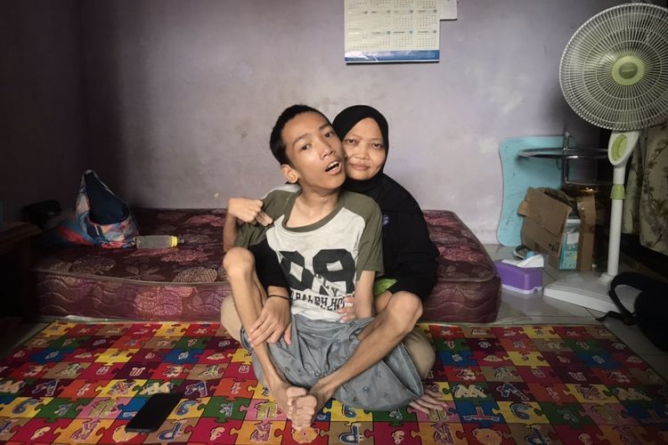 Herna Susila Wati (42) memeluk anaknya Azriel Ilhami Pasha (16)  yang mengalami kerusakan jaringan otak sejak lahir alias Celebral Palsy di rumahnya di kawasan Tanjung Barat, Jagakarsa, Jakarta Selatan pada Rabu (14/6/2023) siang.
