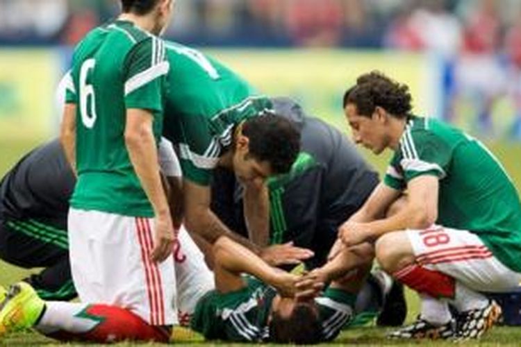 Gelandang tim nasional Meksiko, Luis Montes, mendapat perawatan tim medis pada laga Meksiko melawan Ekuador di AT&T Stadium, Texas, Sabtu (31/5/2014).