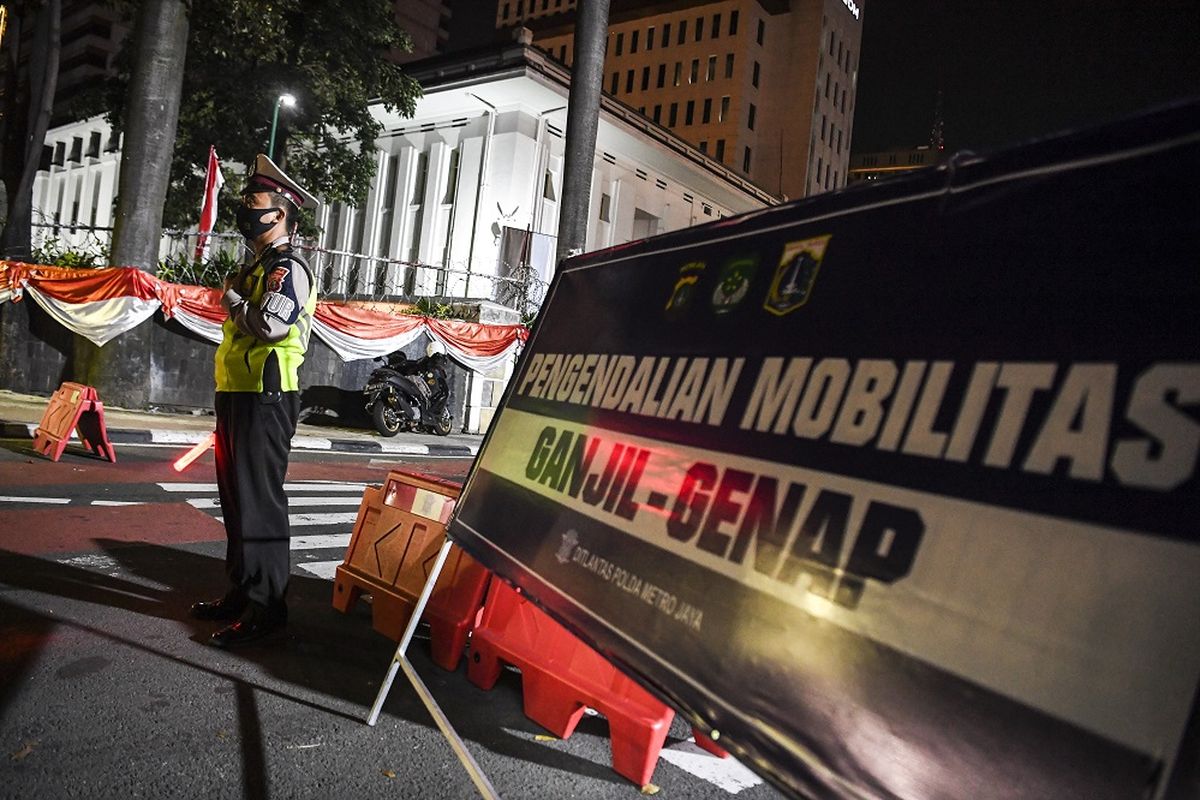 Petugas kepolisian berjaga di pos pemeriksaan ganjil genap yang diterapkan karena adanya perpanjangan PPKM level 4 di Jalan MH Thamrin, Jakarta, Minggu (15/8/2021). ANTARA FOTO/Hafidz Mubarak A/wsj.