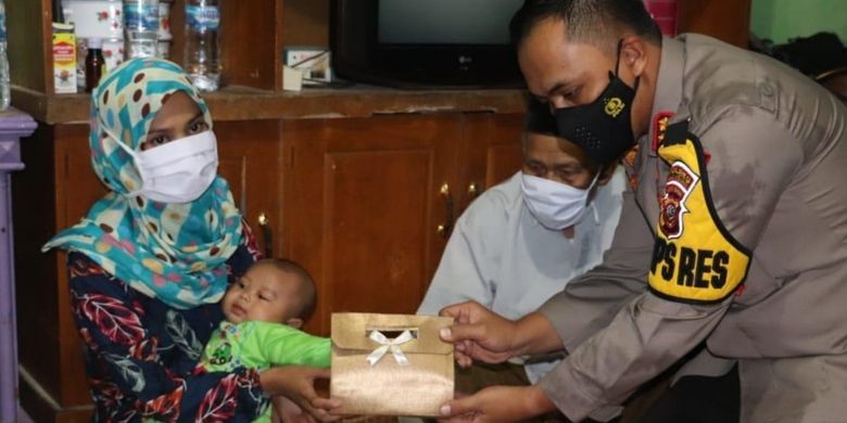 President Jokowi through Sukabumi Police chief Lukman Syarif (Right) gives money to S at her rented house in Sukabumi regency in West Java on Saturday, April 3.