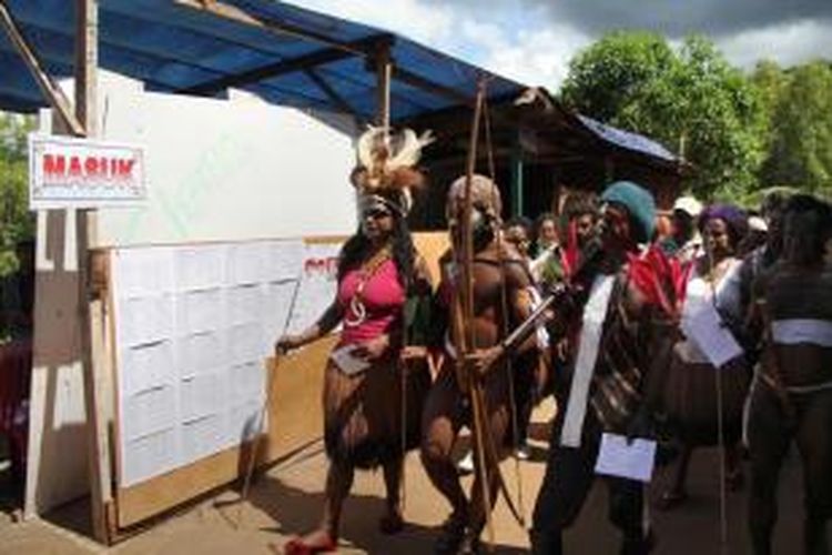 Warga Papua mengenakan pakaian tradisional saat menggunakan hak suara mereka dalam Pemilu Presiden 2014 di Jayapura, Rabu (9/7/2014). Pemilu memilih dua calon presiden yaitu Prabowo Subianto berpasangan dengan Hatta Rajasa dan Joko Widodo berpasangan dengan Jusuf Kalla.