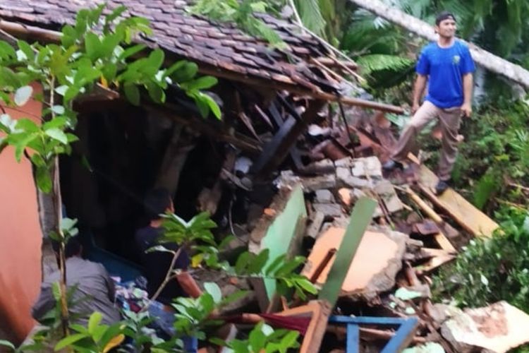 Seorang warga membersihkan puing-puing bangunan rumah rusak akibat tanah longsor di Desa Seuseupan, Kecamatan Caringin, Sukabumi, Jawa Barat, Senin (26/10/2020).