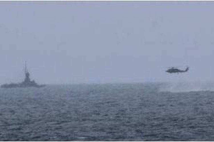 Sebuah helikopter Sea Hawk yang ditempatkan di kapal perusak USS Sampson tengah mendekati kapal patroli Angkatan Laut Indonesia ketika mencari puing-puing  pesawat AirAsia QZ8501.