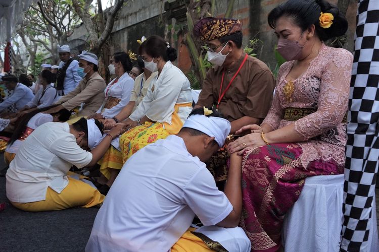 Peserta Upacara Potong Gigi Massal tengah melakukan sungkeman kepada orang tua. Upacara ini diselenggarakan oleh Banjar Ciledug, Tangerang, pada Minggu (3/7/2022) di Pura Dharma Sidhi, Ciledug, Kota Tangerang, Banten.