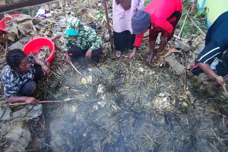 Proses pengangkatan ayam yang selesai dimasak melalui proses bakar batu yang dilakukan oleh Komunitas Muslim Wamena, Jayapura, Papua, Sabtu (24/4/2021)