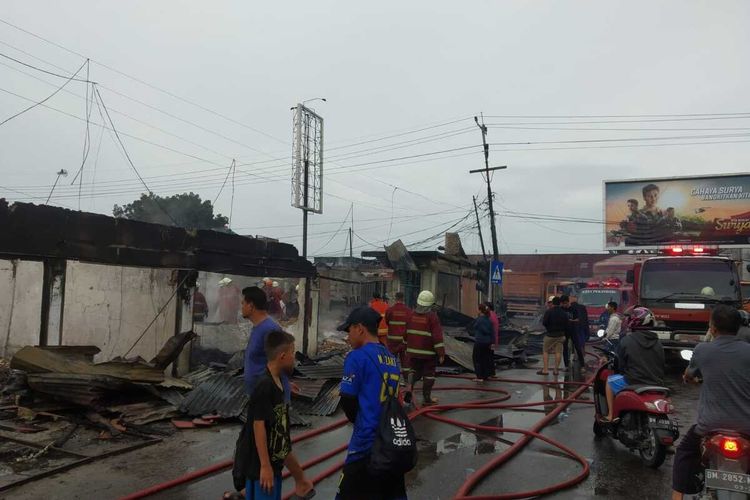 Petugas gabungan berjibaku memadamkan api kebakaran rumah dan puluhan kios pedagang di Jalan Kaharuddin Nasution, Kelurahan Air Dingin, Kecamatan Bukitraya, Kota Pekanbaru, Riau, Minggu (9/10/2022) pagi.