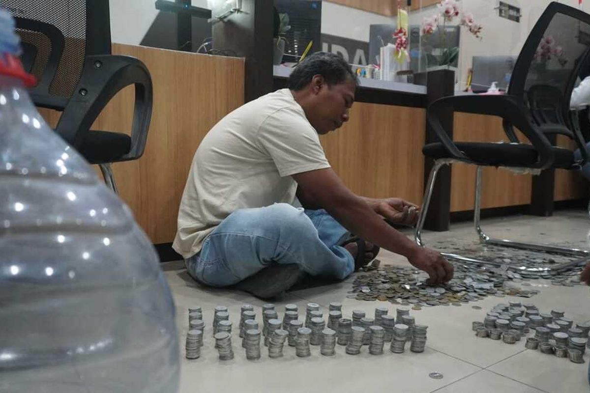 Protes dengan kenaikan tarif PBB-P2, warga Kabupaten Jombang, Jawa Timur, membawa uang koin untuk membayar pajak ke Kantor Badan Pendapatan Daerah (Bapenda) Kabupaten Jombang, Senin (11/8/2025).