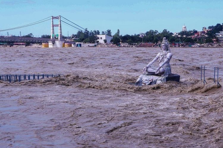Sebuah patung dewa Hindu Dewa Siwa digambarkan di tengah permukaan air Sungai Gangga yang naik setelah hujan terus-menerus di Rishikesh di negara bagian Uttrakhand India pada 19 Oktober 2021. 