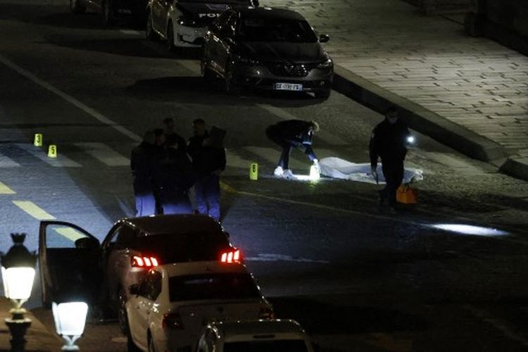Seorang petugas polisi menyelidiki tubuh salah satu dari dua orang yang ditembak oleh polisi di Paris pada 25 April 2022. Tak lama setelah tengah malam pada Minggu malam, polisi melepaskan tembakan ke sebuah mobil yang menolak berhenti di pos pemeriksaan polisi di Pont Neuf di Paris. Polisi mengatakan kepada AFP bahwa mobil itu melaju melawan lalu lintas dan melaju ke arah petugas, yang terpaksa melepaskan tembakan, menurut sumber polisi yang sama. 