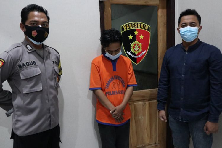 BS (tengah) ditahan petugas kepolisian di Rutan Mapolsek Manyar, Gresik.