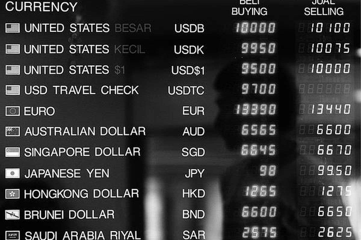 Nasabah mengamati pergerakan nilai tukar rupiah yang fluktuatif melalui papan elektronik di sebuah tempat penukaran uang di Kwitang, Jakarta.