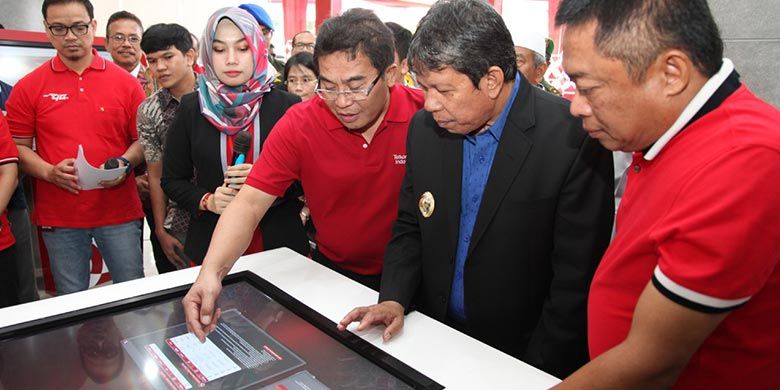 Direktur Utama Telkom Alex J. Sinaga (ketiga dari kanan) memperagakan demo digital table kepada Wakil Walikota Pematangsiantar Togar Sitorus (kedua dari kanan) didampingi Direktur Utama Telkomsel Ririek Adriyansyah di Grapari TelkomGroup Balei Merah Putih Pematangsiantar, Jumat 23 November 2018.