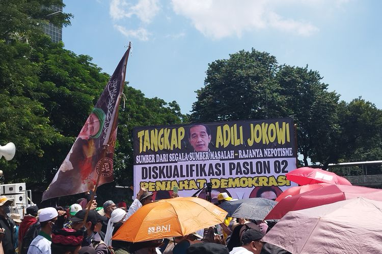Salah satu spanduk yang dipasang saat aksi unjuk rasa di Patung Kuda, Gambir, Jakarta Pusat, Senin (22/4/2024).