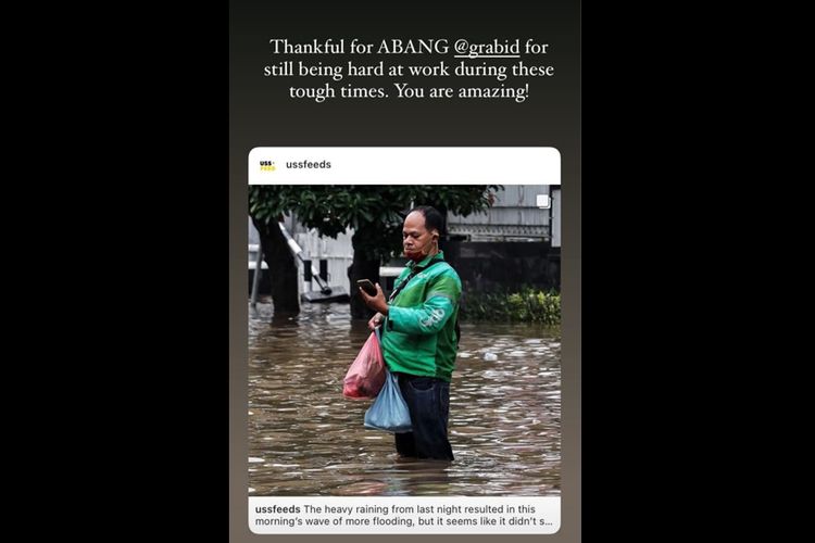 Yudhi Ammaral, seorang pengemudi ojek online Grab mengantarkan pesanan di tengah banjir Jakarta, Sabtu (20/2/2021).