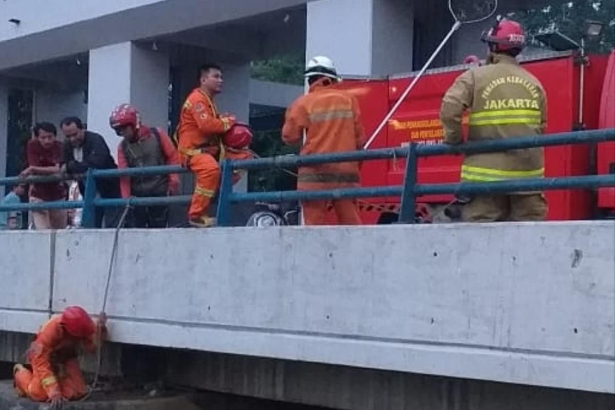 Petugas Sudin PKP Jakarta Timur mengevakuasi bola volly yang tercebur di Pintu Air Kanal Banjir Timur, Duren Sawit, Jakarta Timur, Selasa (9/7/2019).