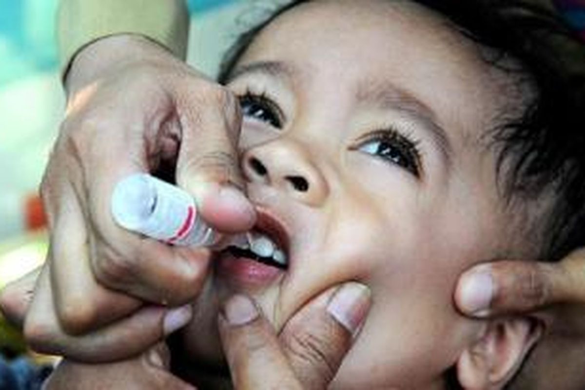 Seorang bocah mendapatkan imunisasi polio.