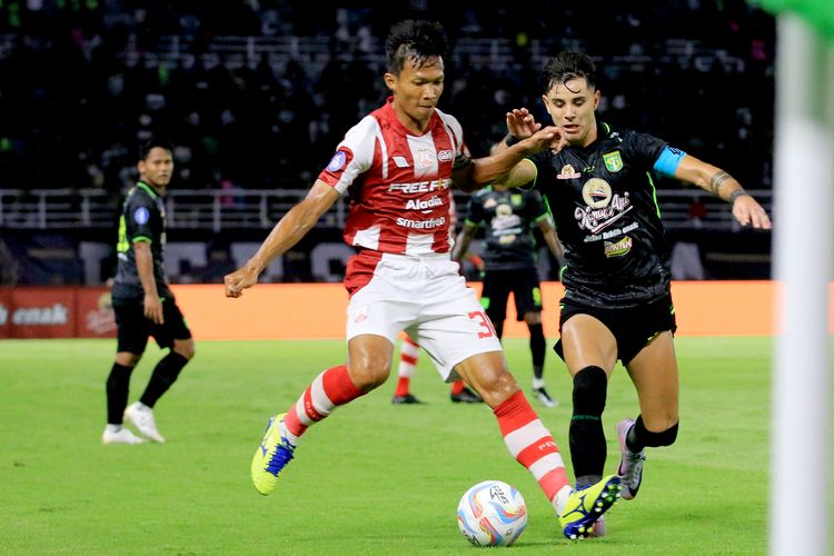 Pemain Persebaya Surabaya Bruno Moreira menjaga pemain Persis Solo Eky Taufik saat laga pekan ke-18 Liga 1 2023-2024 yang berakhir dengan skor 1-1 di Stadion Gelora Bung Tomo Surabaya, Jawa Timur, Rabu (13/12/2023) malam.