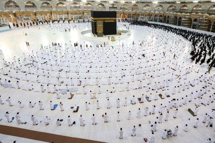 Jamaah Muslim berdoa di sekitar Ka'bah di kompleks Masjidil Haram, tempat suci umat Islam, di kota suci Mekah di Arab Saudi pada 1 November 2020, ketika pihak berwenang memperluas ziarah umrah sepanjang tahun untuk menampung lebih banyak jemaah sambil melonggarkan pembatasan pandemi coronavirus COVID-19 . - Pihak berwenang Saudi sebelumnya telah mengumumkan bahwa tahap ketiga dari perluasan doa mulai dari 1 November akan mengizinkan pengunjung dari luar negeri. Batas jemaah umrah kemudian akan dinaikkan menjadi 20.000, dengan total 60.000 jemaah diperbolehkan. 