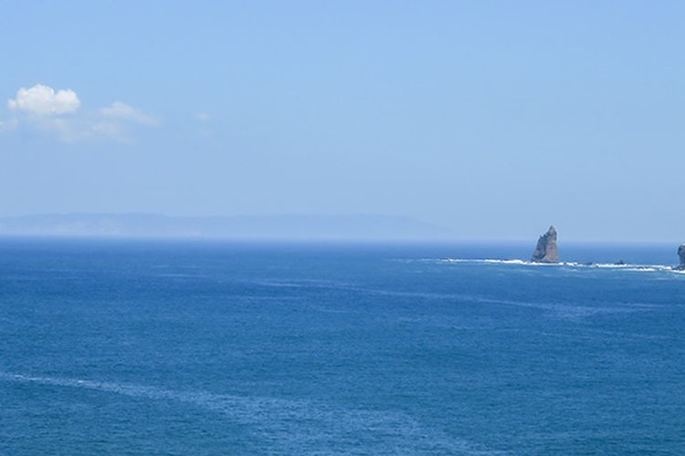 Pemandangan Pulau Nusa Barong di ufuk barat dari Bukit Samboja Pantai Payangan.