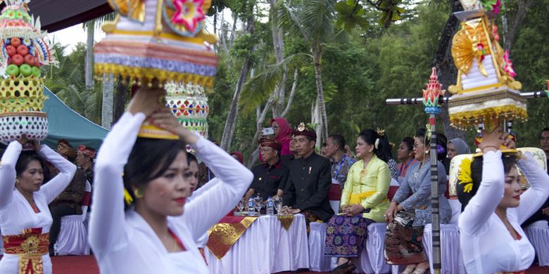 Presiden Joko Widodo (ketiga kanan), Ibu Negara Iriana Joko Widodo (kanan) dan Gubernur Bali I Wayan Koster (kiri) menyaksikan ritual Banten Gebogan saat Karnaval Budaya Bali di kawasan Nusa Dua, Bali, Jumat (12/10/2018). Karnaval tersebut merupakan rangkaian acara dari Pertemuan Tahunan IMF - World Bank Group 2018 di Bali. 