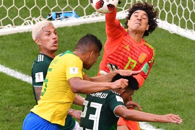 Guillermo Ochoa lebih cepat daripada Casemiro dalam menyambut bola pada pertandingan Brasil vs Meksko dalam babak 16 besar Piala Dunia 2018 di Samara Arena, 2 Juli 2018. 