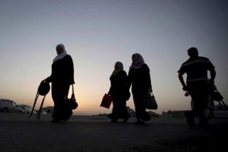 Warga Palestina berjalan menuju pos pemeriksaan Qalandia antara kota Ramallah, Tepi Barat dengan Jerusalem untuk shalat di Masjid Al-Aqsa di Jerusalem, pada Jumat pertama di bulan Ramadhan, 19 Juni 2015.