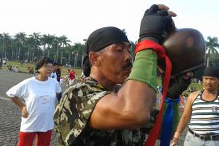 Kopral Bagyo saat meminum air dari kendi di sela-sela aksi memutar Monas 25 Jam, Minggu (7/7/2013)