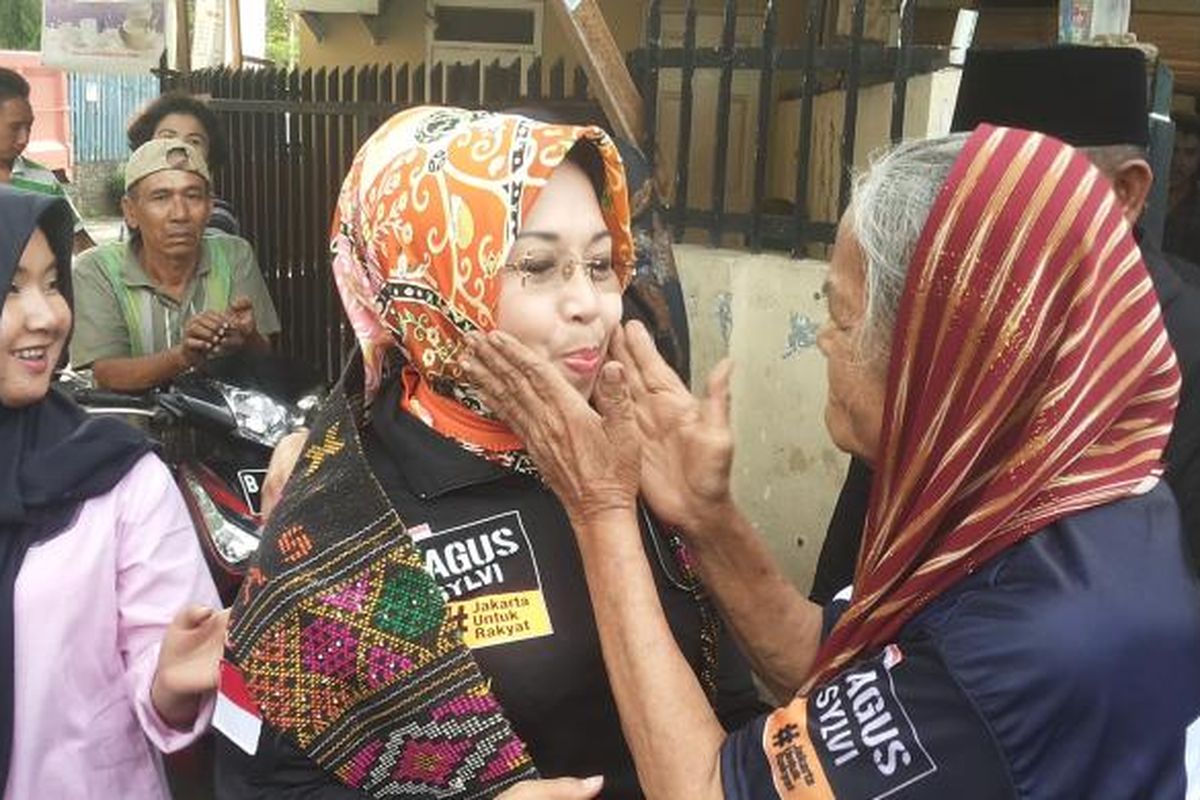 Calon wakil gubernur DKI Jakarta nomor pemilihan satu Sylviana Murni dikalungkan sehelai kain ulos oleh salah seorang warga RT 04/RW 09 Kelurahan Bidara Cina, Jatinegara, Jakarta Timur saat kunjungannya ke lokasi tersebut pada Senin (6/2/2017) sore.