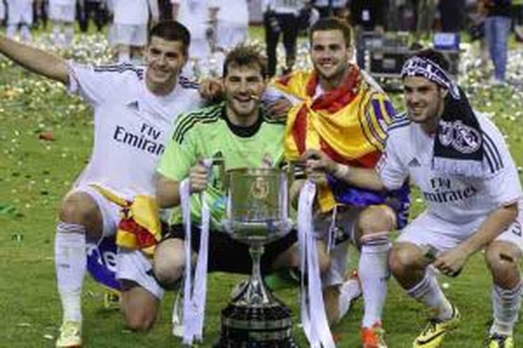 (Dari kiri ke kanan): Striker Real Madrid Alvaro Morata, penjaga gawang Iker Casillas, gelandang Nacho dan Isco berpose dengan trofi Copa del Rey yang mereka raih usai menang 2-1 atas Barcelona di final, Rabu (16/4/2014) di Mestalla.
