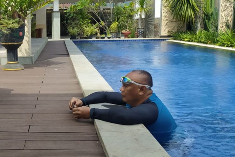 Gubernur Gorontalo Rusli Habibie berada di kolam renang saat menjalani isolasi mandiri di kediaman pribadinya di Kelurahan Moodu, Kota Gorontalo, Jumat (23/7/2021). Rusli bersama istri dinyatakan positif covid-19 pada Rabu malam.