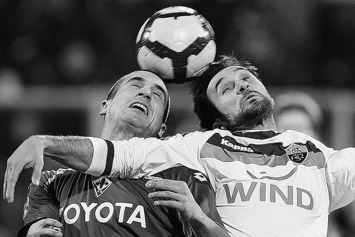 Pemain AS Roma, Mirko Vucinic (kanan), menggunakan tangannya untuk memenangi perebutan bola dengan pemain Fiorentina, Lorenzo De Silvestri, dalam pertandingan Serie A di Stadion Artemio Franchi, Florence, Italia, Minggu (7/2). AS Roma menang tipis, 1-0.