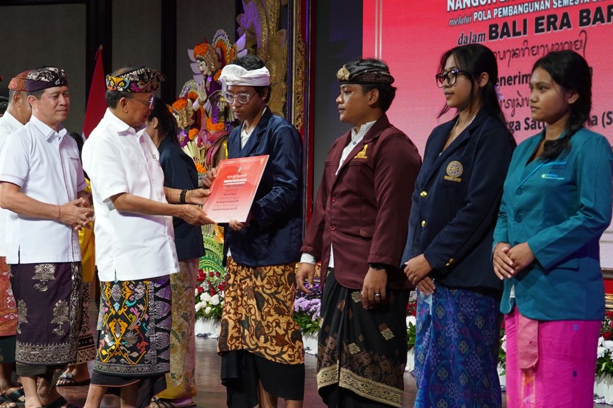 Gubernur Bali Wayan Koster menyerahkan bantuan beasiswa program Satu Keluarga Satu Sarjana (SKSS) di Gedung Ksirarnawa, Art Centre Denpasar, Selasa (23/12/2025), 
