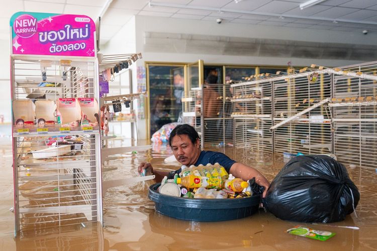 Seorang pria korban banjir Thailand membawa bak berisi minuman di toko swalayan Kota Hat Yai, Provinsi Songkhla, 26 November 2025. Banjir Thailand kali ini menewaskan sedikitnya 55 orang.