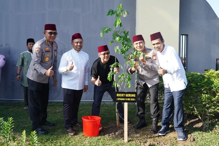 Intelektual publik Rocky Gerung berfoto di depan pohon yang ia tanam bersama Gubernur Riau Abdul Wahid, Kapolda Riau Irjen Hery Heryawan, dan Ustaz Abdul Somad (UAS) usai acara Kajian Subuh Ilmiah dan Menanam Pohon di Mapolda Riau, Sabtu (10/5/2025).