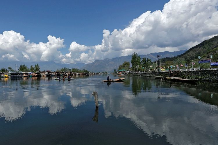 Seorang pria mendayung perahu kecilnya di perairan Danau Dal menjelang Hari Bumi, di tengah kekhawatiran tentang penyebaran penyakit coronavirus (COVID-19), di Srinagar 2 April 2020. REUTERS / Danish Ismail