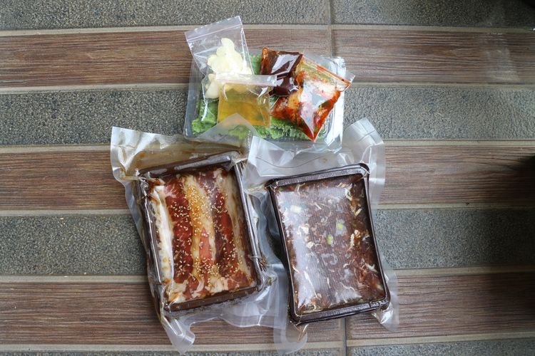 dua varian frozen beef dari Pochajjang, Frozen Wagyu Beef Bulgogi dan Frozen Premium Beef Spicy Bulgogi lengkap dengan selada, bawang putih, minyak wijen, kimchi, dan saus gochujang