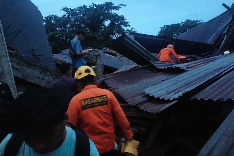 Petugas Basarnas sedang mengevakuasi korban yang terjebak reruntuhan sebagai dampak gempa di Mamuju, Sulawesi Barat, Jumat (15/1/2021)