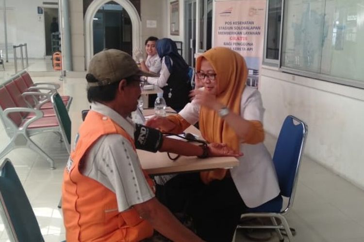 Petugas kesehatan sedang memeriksa kesehatan penumpang kereta api di Stasiun Solo Balapan, Solo, Jawa Tengah, Selasa (31/12/2019).