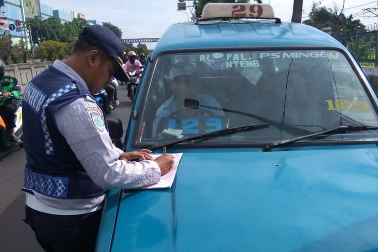 Petugas Dishub tilang angkutan umum di Kawasan Pasar Minggu, Jakarta Selatan, Selasa (9/7/2019)