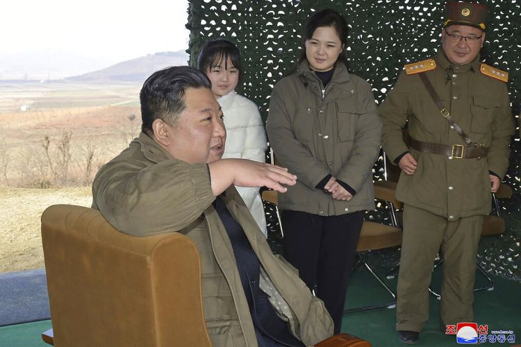 Foto pemerintah Korea Utara tanggal 19 November 2022 ini menunjukkan Presiden Kim Jong Un, depan, saat dia berbicara, ditemani oleh istrinya Ri Sol Ju (kedua dari kanan), dan putri mereka, saat mereka mengawasi peluncuran uji coba yang dikatakan sebagai Hwasong -17 ICBM di Bandara Internasional Pyongyang pada Jumat, 19 November 2022. Korea Utara dilaporkan pada Jumat (30/12/2022), telah memberlakukan larangan total terhadap pelancong atau pengunjung dari China di tengah kekhawatiran akan gelombang Covid-19 yang kembali melanda Negeri Tirai Bambu.