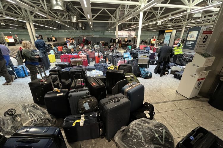 Koper-koper memadati tempat pengambilan bagasi di Terminal Tiga Bandara Heathrow, London, Inggris, (08/07/2022).