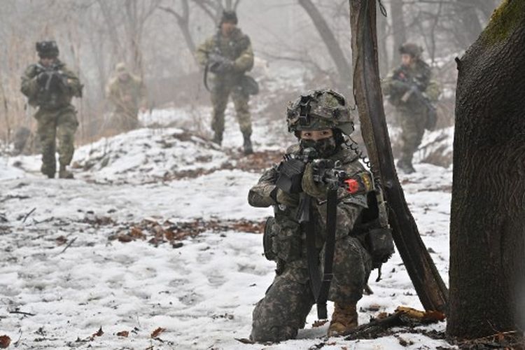 Seorang tentara Korea Selatan (depan) dan tentara AS berpartisipasi dalam latihan militer bersama antara Batalyon Stryker Divisi Infanteri ke-2 AS dan Brigade Demonstrasi Harimau Divisi Infanteri ke-25 ROK di lapangan pelatihan di Paju pada 13 Januari 2023. Pada Minggu (29/1/2023), seorang tentara Korea Selatan dilaporkan secara keliru menembakkan senapan mesin di dekat perbatasan dengan Korea Utara.