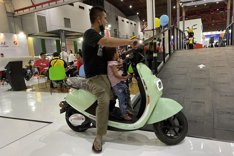 Pengunjung Jakarta Fair 2023 menjajal motor listrik di area test ride indoor