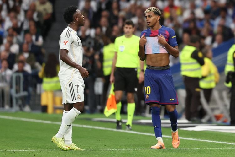 Vinicius Junior (kiri) berbicara dengan Lamine Yamal dalam pertandingan Liga Spanyol antara Real Madrid vs Barcelona di Stadion Santiago Bernabeu di Madrid pada 26 Oktober 2025. (Foto oleh Oscar DEL POZO / AFP)