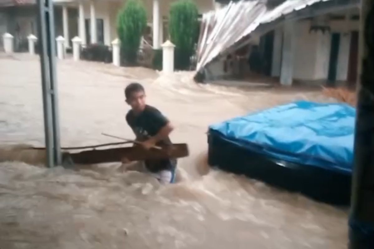 Tangkapan layar dari vidio yang memperlihatkan keadaan di salah satu daerah di Kecamatan Cidolog Kabupaten Sukabumi terjadi banjir, dan seseorang tengah berusaha menyelamatkan kendaraan roda empat yang terkena banjir pada Senin (28/7/2025)